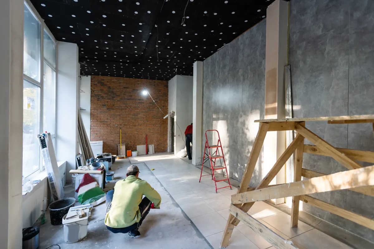 Reforma integral de vivienda — albañil colocando baldosas